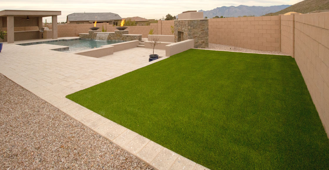 Picture of a modern and clean patio with a little lawn and a pool with waterfall