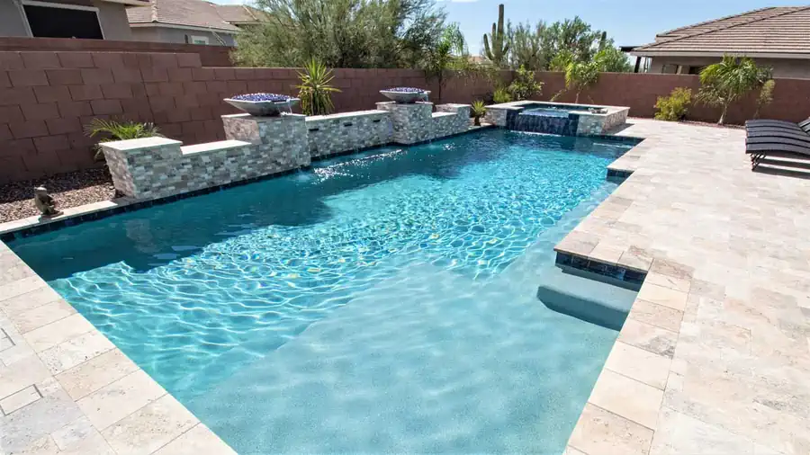 A luxury custom pool in a Tucson backyard with elegant hardscape, desert landscaping, and a compact but thoughtfully designed layout.