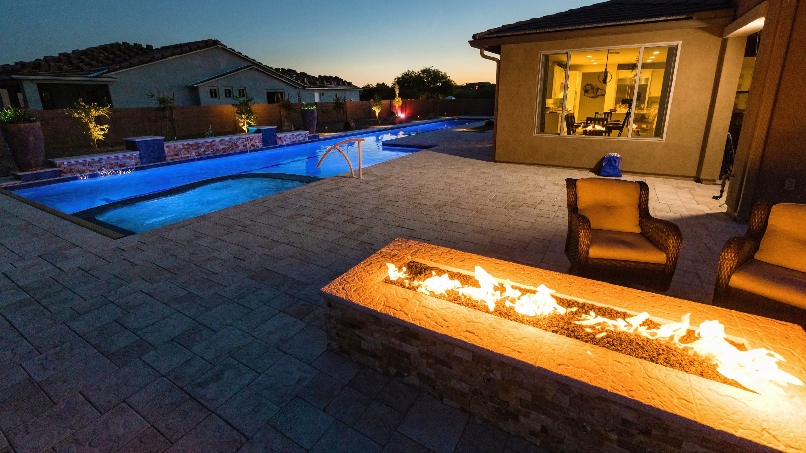 Night picture of a patio stove with a pool in the background